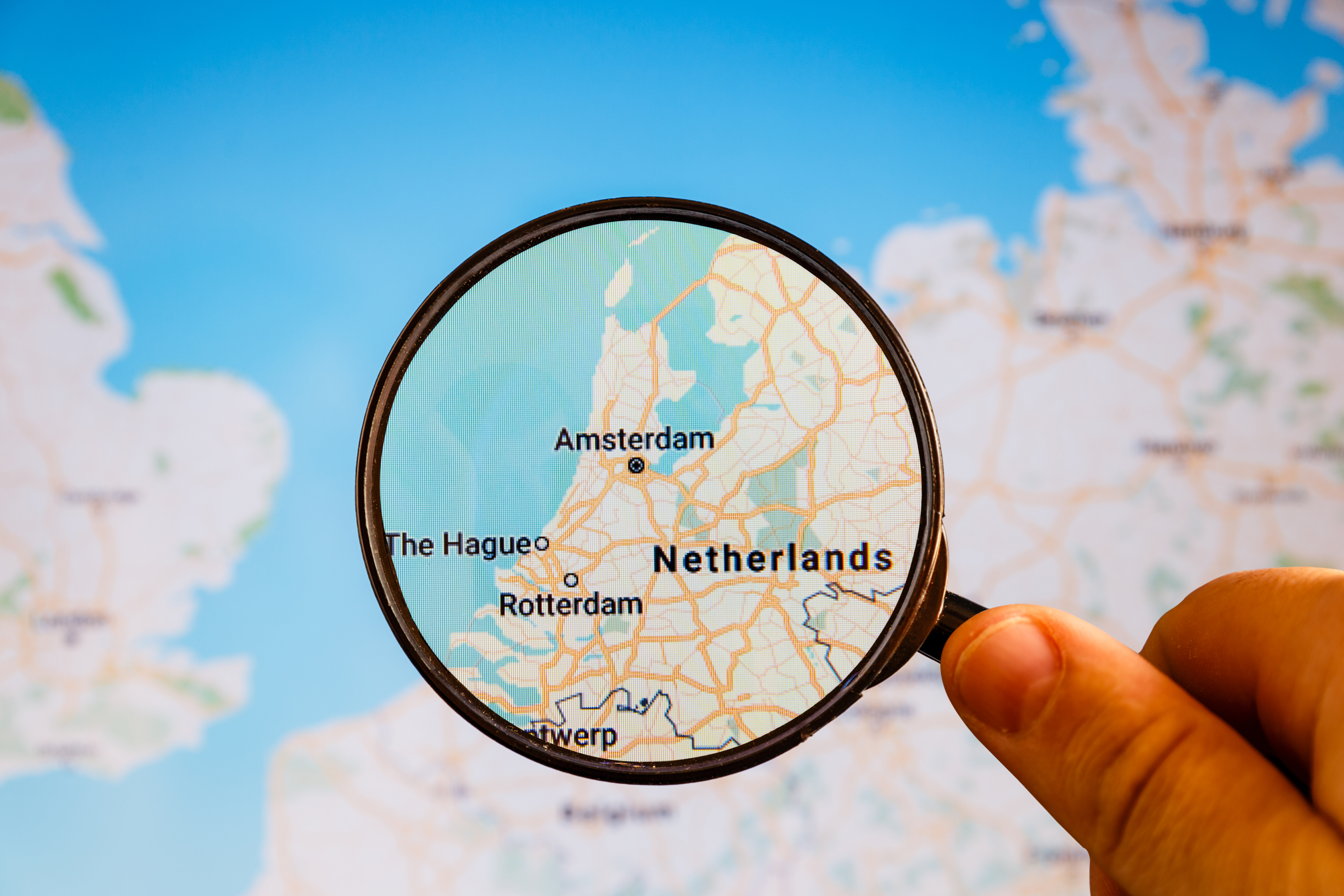 Лупа и карта Нидерландов, где иностранцам для трудоустройства надо оформлять рабочую визу