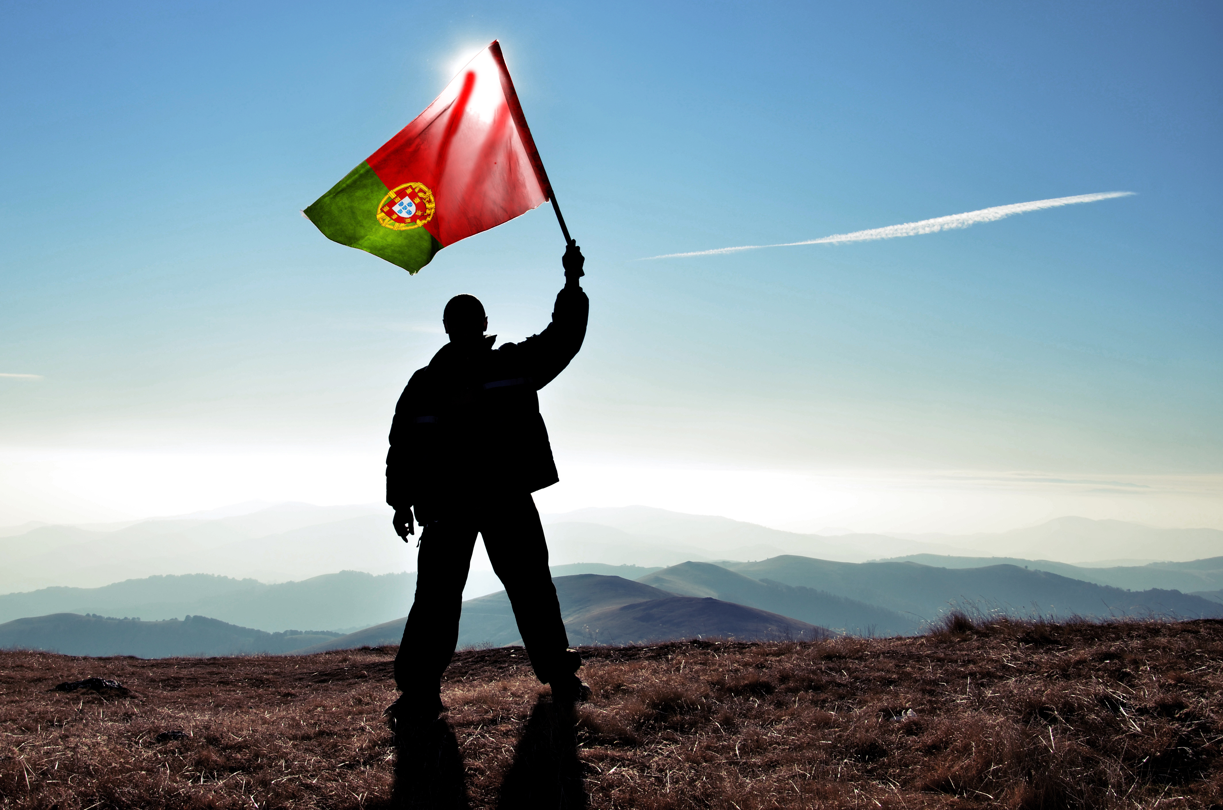 Мужчина с флагом Португалии, где рабочую визу могут оформить иностранные работники