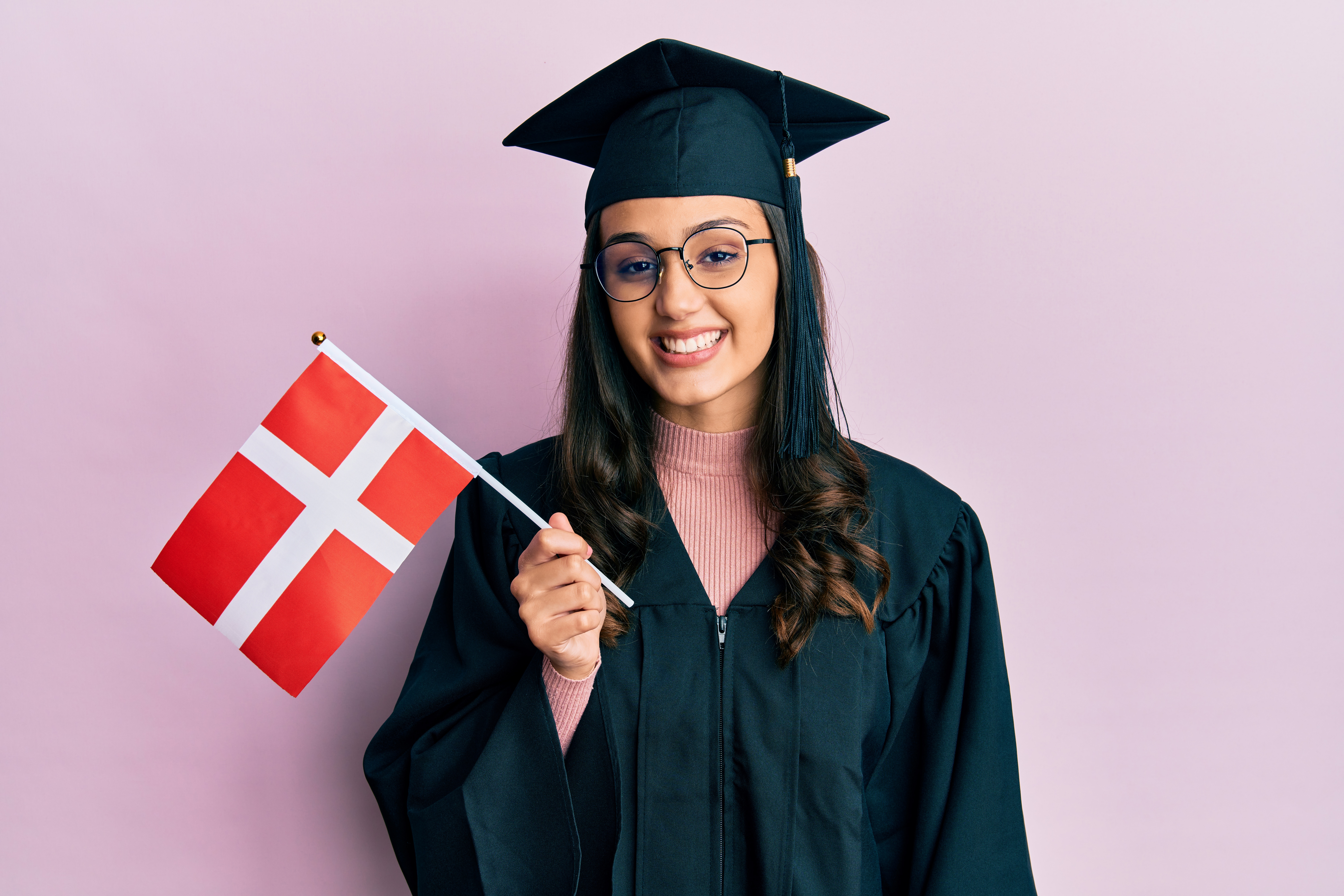 Девушка с флагом Дании, где для учебы иностранцам надо оформлять студенческую визу