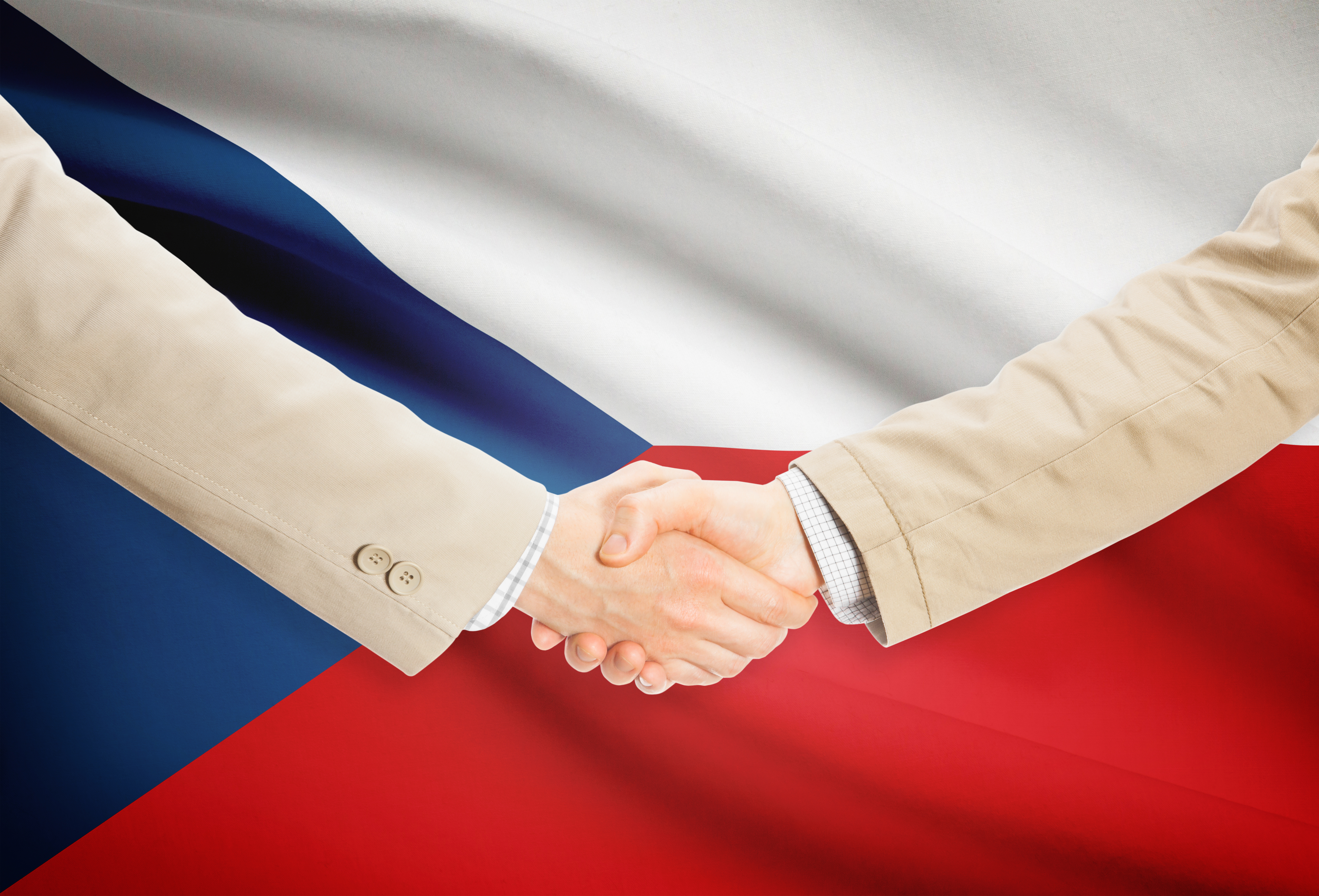 Рукопожатие на фоне флага Чехии, куда можно переехать по трудоустройству